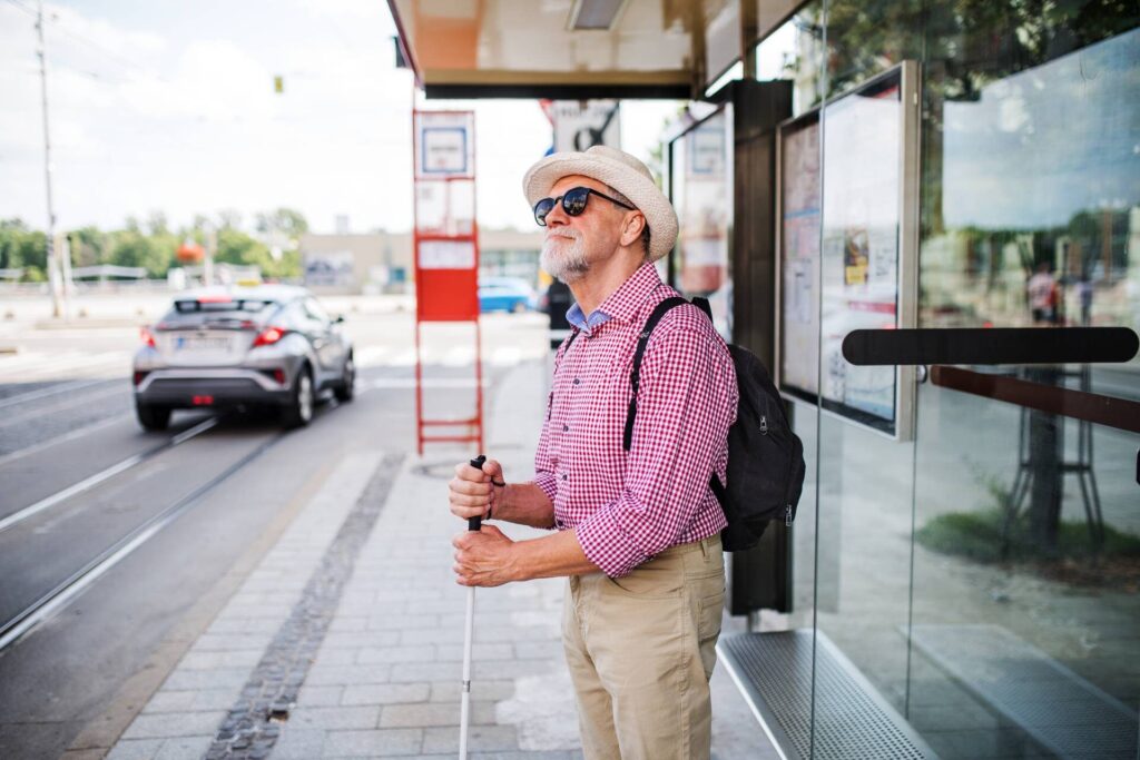 senior-blind-man-with-white-cane-waiting-at-bus